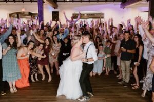 bride and groom kissing while guests cheer