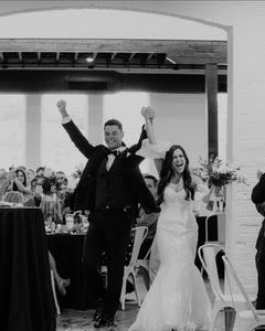 bride and groom cheering while entering wedding reception